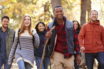 Group of six friends hiking together through a forest - Powered by Adobe