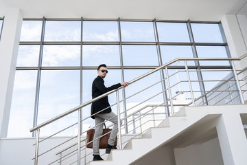 Side view of stylish man going up on steps