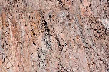 view on a rock wall of open pit mine. porphyry rocks