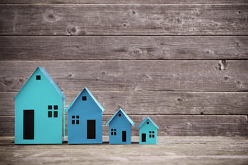 A paper houses stands over a wooden background