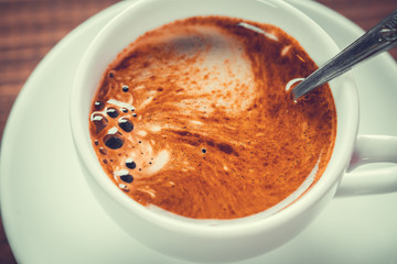 Beautiful background with a hot Cup of coffee with Crema on wooden background