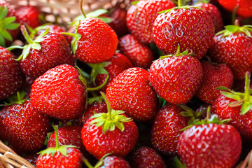 Very beautiful background with fresh strawberries in a wicker heart shaped wickerwork basket