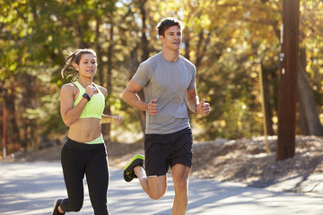 Caucasian woman and man jogging on a country road, close up