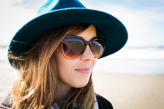 Portrait of stylish woman wearing felt hat and sunglasses, Dillon Beach, California, USA