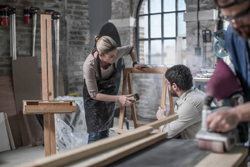Carpenter team sanding wood in antique restoration workshop