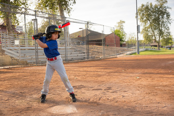 Boy batting at practise on baseball field