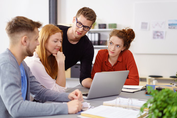 junge geschäftsleute sitzen am schreibtisch und beprechen ein projekt © contrastwerkstatt
