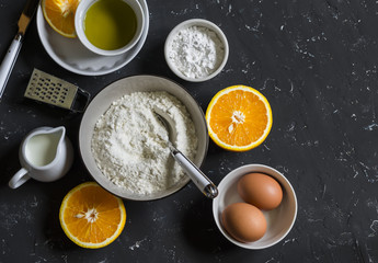 Ingredients for making orange cake with olive oil - flour, eggs, olive oil, powdered sugar on a...