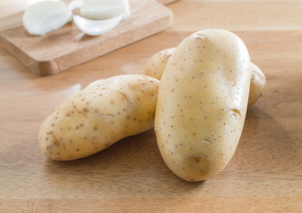 Fresh potatoes on wooden table in a kitchen