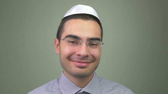 Young jewish hebrew man smiling and looking friendly .