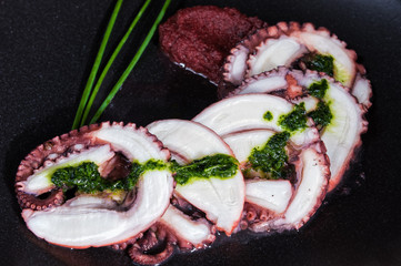 Octopus carpaccio on black dish