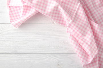 Pink cloth on wooden background. Napkin tablecloth on white wood with empty space for text. Top view.