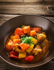 Stewed meat with vegetables in ceramic bowl.