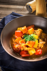 Stewed meat with vegetables in ceramic bowl.