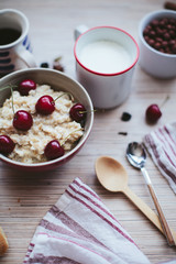 rich breakfast of porridge with cherries and pastry