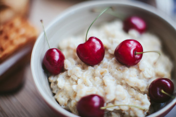 rich breakfast of porridge with cherries and pastry
