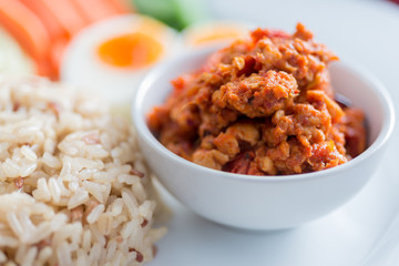 Foods series : Spicy chicken and tomato dip, served with brown rice, boiled egg and fresh vegetable, Thai foods, northern style, selective focus