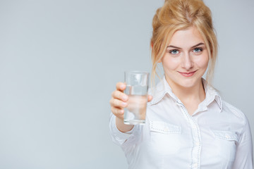 Smiling cute young businesswoman giving you a glass of water