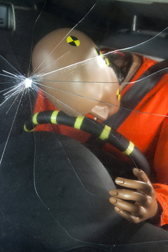 A windshield cracked by the impact of a crash test dummy's head
