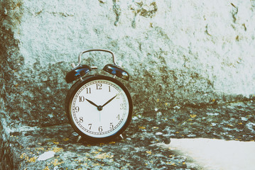 Alarm clock on the stone wall