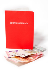 Sparbuch stehend, mit Geldscheinen davor