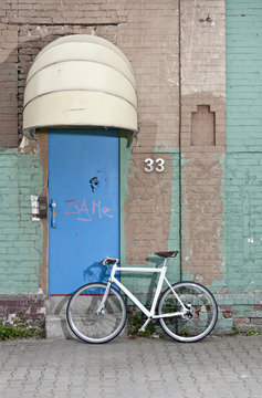 A bicycle in front of a rundown building