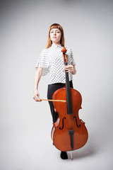 Young cellist standing and playing the cello