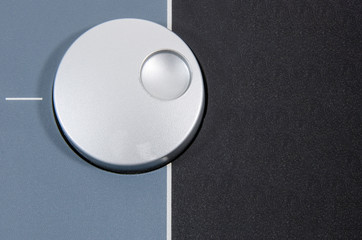closeup top view of a round chrome dial button