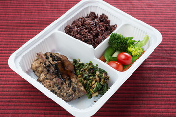 Food series : Grilled chicken breast with herbs, served with brown rice and fresh vegetable in plastic box, Thai foods 