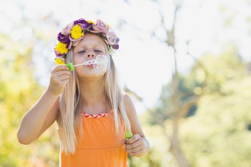 Young girl blowing bubbles through bubble wand