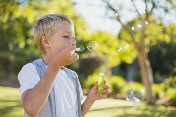 Young boy blowing bubbles through bubble wand