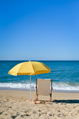 Chair and umbrella on stunning tropical beach background vacation