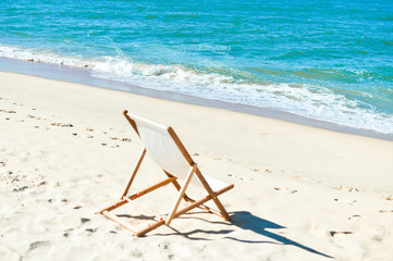 Fototapeta na wymiar Back View Of Deckchair On Sandy Beach.