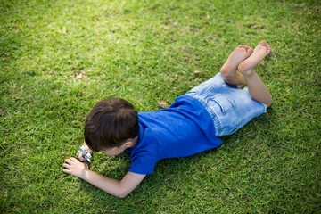Fototapeta premium Boy examining grass with a magnifying glass