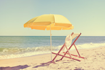 Female hat, chair and umbrella on stunning tropical beach background vacation 