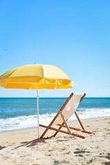 Sun parasol, chair longue and female hat on vacation beach sun shine 