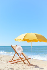 Sun parasol, chair longue and female hat on vacation beach sun shine 