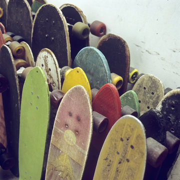 Rows of used skateboards leaning against a wall