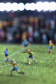 Miniature figurines of two soccer teams playing a soccer match