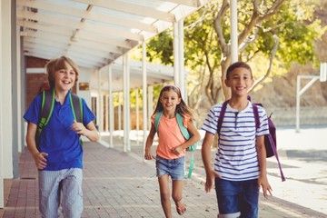 Happy school kids running in corridor