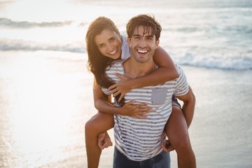 Fototapeta premium Man giving woman piggyback ride 