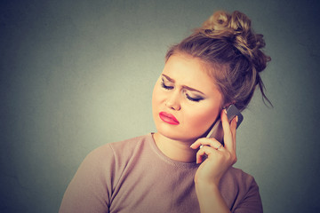Upset sad annoyed unhappy woman talking on cell phone
