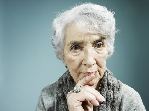 A senior woman thinking with her index finger to her lips
