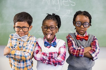 Portrait of three school kids standing against chalkboard
