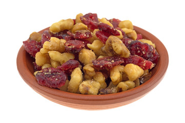 Cranberries and walnuts in a small bowl isolated on a white background.