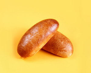 Fresh pies and buns with meat and vegetables on yellow background. Pastries and bread in a bakery