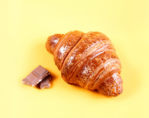 Tasty croissant with chocolate and jam on yellow background. Pastries and bread in a bakery