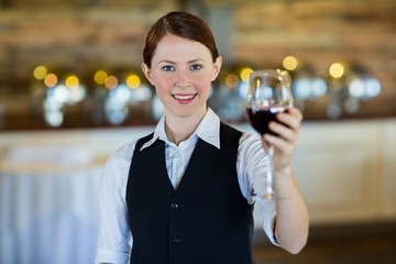 Waitress holding up a wine glass 