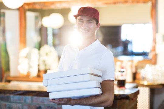 Pizza delivery man holding pizza boxes 