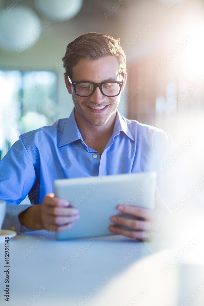Poster Smiling man using digital tablet
